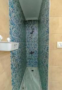 a bathroom with a shower with blue mosaic tiles at SARAYA AWAD HEGAZI STREET- families only in Alexandria +248 photos