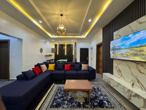 un soggiorno con un divano blu e una TV di Declans Shortlet ad Abuja
