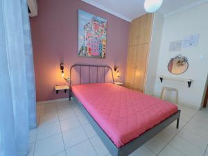 una camera da letto con un letto rosa in una stanza di The Romantic Traveller a Kavala