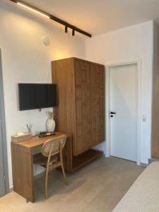 a bedroom with a desk and a tv on a wall at Salvia di Astypalea in Livadi Astypalaias