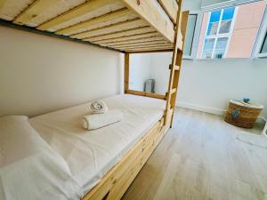 a bedroom with a bunk bed with a ladder at La Casa de la Yaya - Malaga beach! in Málaga