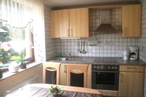 a kitchen with wooden cabinets and a sink and a stove at Ferienwohnung-Geschwind in Schleiden