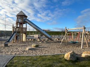 a playground with a slide in a park at Ferienhaus Nordseejuwel in Friedrichskoog-Spitze