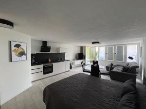 une chambre avec un lit et un salon avec un canapé dans l'établissement Terrassenpark Apartments (Premium Rooms), à Sasbachwalden