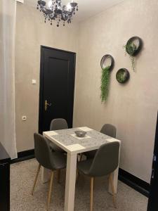 comedor con mesa, sillas y puerta negra en Okapi stays, en Belgrado
