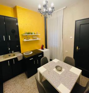 cocina con mesa y pared amarilla en Okapi stays, en Belgrado