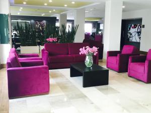 a lobby with purple couches and a vase of flowers at Hotel HAUS Ixtaczoquitl&aacute;n in Orizaba