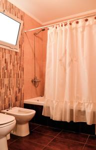 a bathroom with a toilet and a shower curtain at Los Llantenes in San Andres de las Sierras