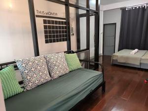 a couch with pillows on it in a room at Charoen Nakhon 48 House in Godown