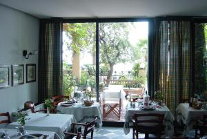 um restaurante com mesas e cadeiras e uma grande janela em Hotel Beau Rivage em Alassio