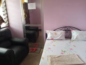 a small bedroom with a bed and a chair at Mumbai lodge in Bagamoyo