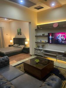 a living room with a couch and a tv at Enjoy a Cozy, Peaceful Space with Self Check-In in Multan