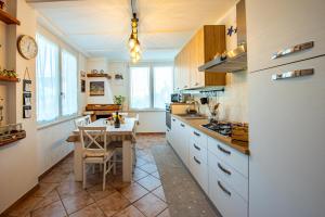 a kitchen with white cabinets and a table in it at A casa di Colomba in Minturno