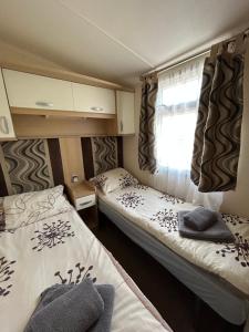 ein kleines Zimmer mit zwei Betten und einem Fenster in der Unterkunft Camping Marina Nowe Guty in Nowe Guty