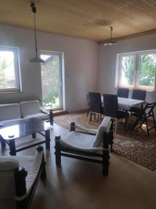 a living room with a couch and a table and chairs at Apartament u Romana, in Tałty
