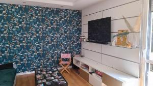 a living room with a wall with a floral wallpaper at Maison loft Côte de Granit Rose in Saint-Quay-Perros