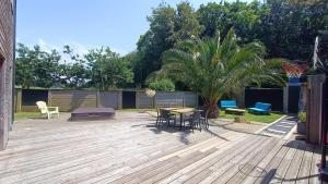 a patio with a table and chairs on a wooden deck at Maison loft Côte de Granit Rose in Saint-Quay-Perros
