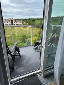 a screened in porch with two chairs and a view at Villa Na Fali in Grzybowo