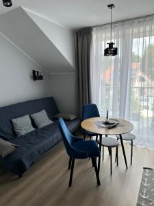 a living room with a blue couch and a table at Villa Na Fali in Grzybowo
