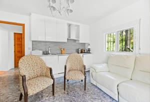 a living room with a white couch and a kitchen at Casa de las Risas B&B in Alhaurín el Grande