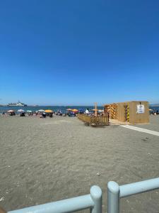una vista su una spiaggia con persone in piedi sulla sabbia di House Vacations Center a Castellammare di Stabia