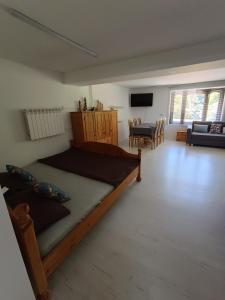 a bedroom with a large bed and a living room at Agroturystyka Rudy Kocur Różana 24 Jaroszowice in Jaroszowice