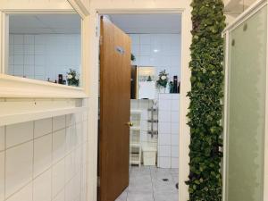 una porta aperta su una cucina con una parete verde di Nice room less Pay near Port Adelaide a Rosewater