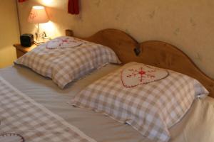 Duas camas com almofadas num quarto em Chambre d'hôtes "LES CRETS" em Mercury