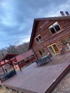 a large wooden deck in front of a house at Magasbükk Drakula Kulcsosház Ivó in Izvoare