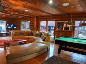 a living room with couches and a pool table at Magasbükk Drakula Kulcsosház Ivó in Izvoare