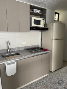 a kitchen with a stainless steel refrigerator and a microwave at City House Group Girona in Ibagué