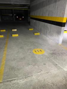 a yellow sign on the floor of a parking garage at City House Group Girona in Ibagué