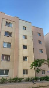 a tan building with a tree in front of it at Lana's Studio in King Abdullah Economic City