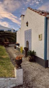 a small building with flowers in front of it at Quinta do Monte Santo in Vila do Porto