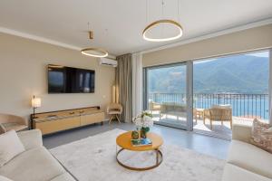 a living room with a couch and a large window at Sea Breeze Residence in Kotor