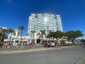 a group of people walking down a street in front of a tall building at Amazing Perfect Family Home - GC Beach location in Gold Coast