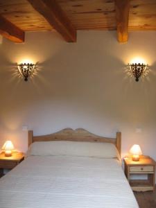 a bedroom with a bed with two lights on the wall at Gîte Le Pigeonnier10P, Ste Enimie,Gorges du tarn, village de Saint Chély du Tarn 