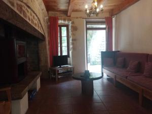 a living room with a couch and a tv at Gîte Le Pigeonnier10P, Ste Enimie,Gorges du tarn, village de Saint Chély du Tarn 
