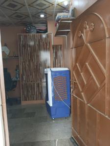 ein Raum mit einer blauen Heizung und einer Holztür in der Unterkunft FASTCOM Flat in Karatschi