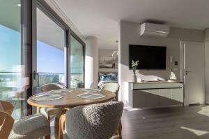 a living room with a table and chairs and a television at Waveview Premium Apartment Międzyzdroje in Międzyzdroje