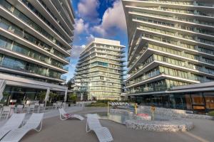 a group of buildings with white chairs in a courtyard at Waveview Premium Apartment Międzyzdroje in Międzyzdroje