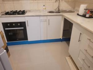 a white kitchen with a sink and a stove at Casa da Alegria in São Tiago