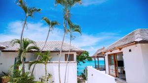 a house with palm trees in front of the ocean at Luxurious Bali-style 5-bedroom sea view pool villa at Bophut Beach, Koh Samui, close to Chaweng Beach in Amphoe Koh Samui