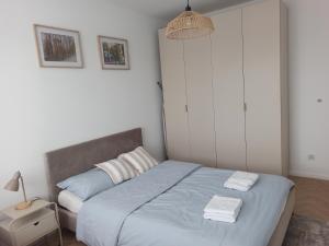a bedroom with a bed with two towels on it at Apartament Czartoryskich House z miejscem postojowym w garażu podziemnym in Puławy