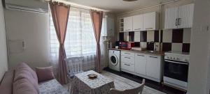a living room with a couch and a table in a kitchen at Feels like home in Deva
