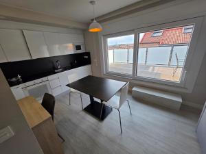a kitchen and dining room with a table and a window at Apartahotel Aranda Flex Living in Aranda de Duero