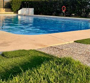 a blue swimming pool with a red life preserver in a yard at Apartamento en villa bellavista in Almerimar