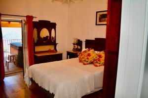 ein Schlafzimmer mit einem Bett und einem Spiegel in der Unterkunft Assento Gerês - Grand Eco-Retreat - jacuzzi views in Lindoso