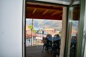 eine Terrasse mit Tisch und Stühlen auf einem Balkon in der Unterkunft Assento Gerês - Grand Eco-Retreat - jacuzzi views in Lindoso + 133 Fotos