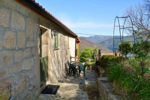 ein Tisch und Stühle vor einem Gebäude in der Unterkunft Assento Gerês - Grand Eco-Retreat - jacuzzi views in Lindoso